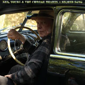 Pochette de l'album Second Song de Neil Young & The Chrome Hearts, l'artiste au volant d'une vieille voiture