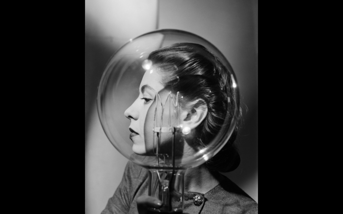 Portrait en noir et blanc d'une femme de profil derriere une grande ampoule, visuel de l'exposition Lee Miller au Musee d'Art Moderne de Paris