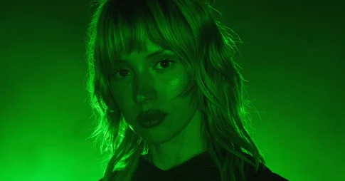 Angèle éclairée d'une lumière verte, dans l'esthétique électro de son album Instinct