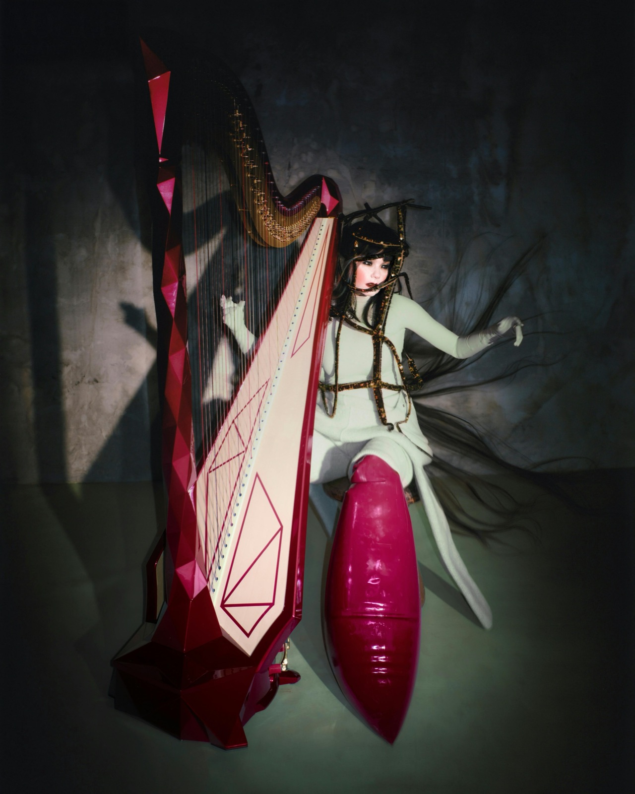 Bjork assise pres d'une harpe rouge, visuel de l'exposition Echolalia a la Galerie nationale d'Islande