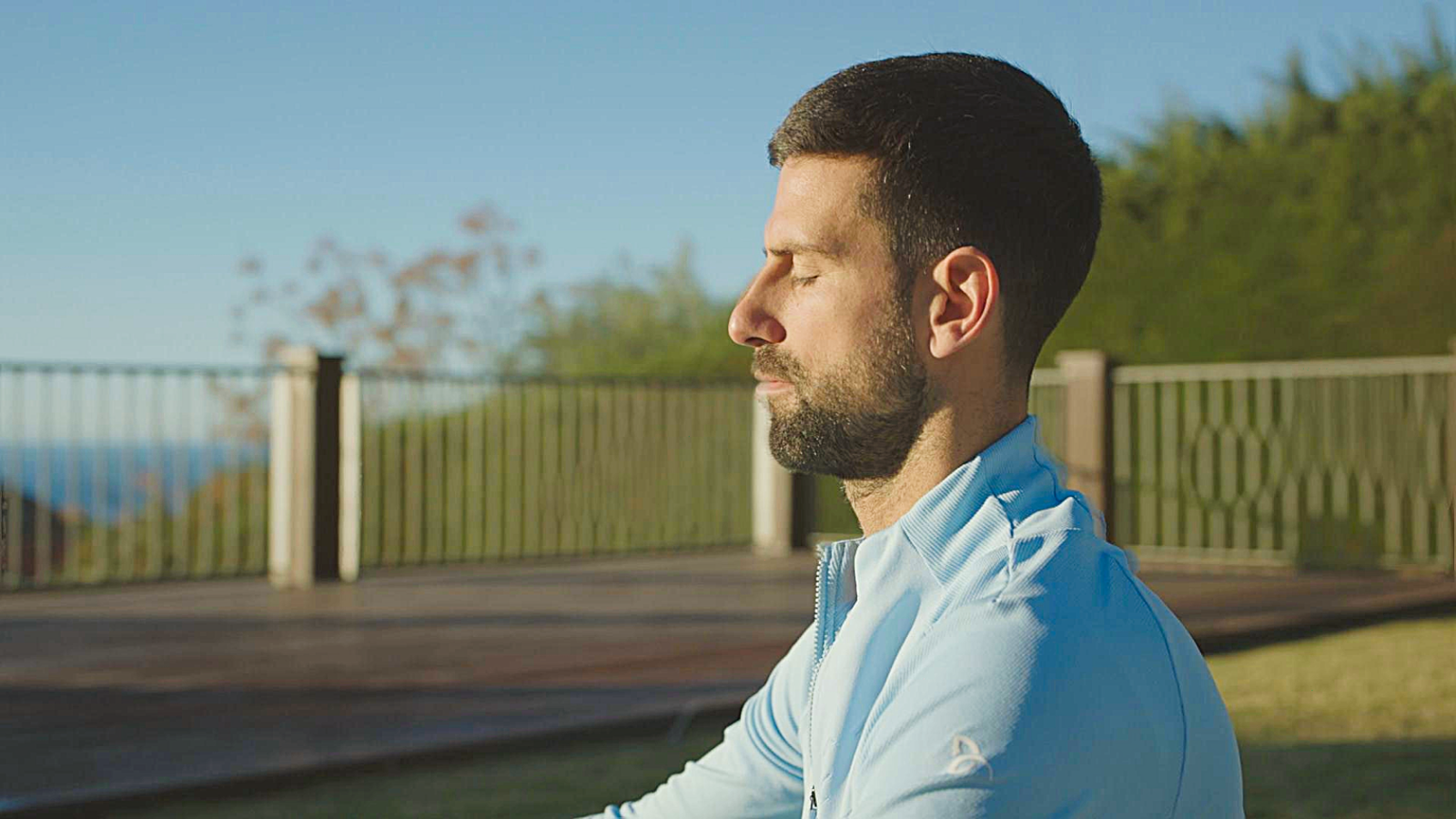 Novak Djokovic yeux fermes en train de mediter au soleil, image officielle du documentaire Prime Video Le Loup en hiver
