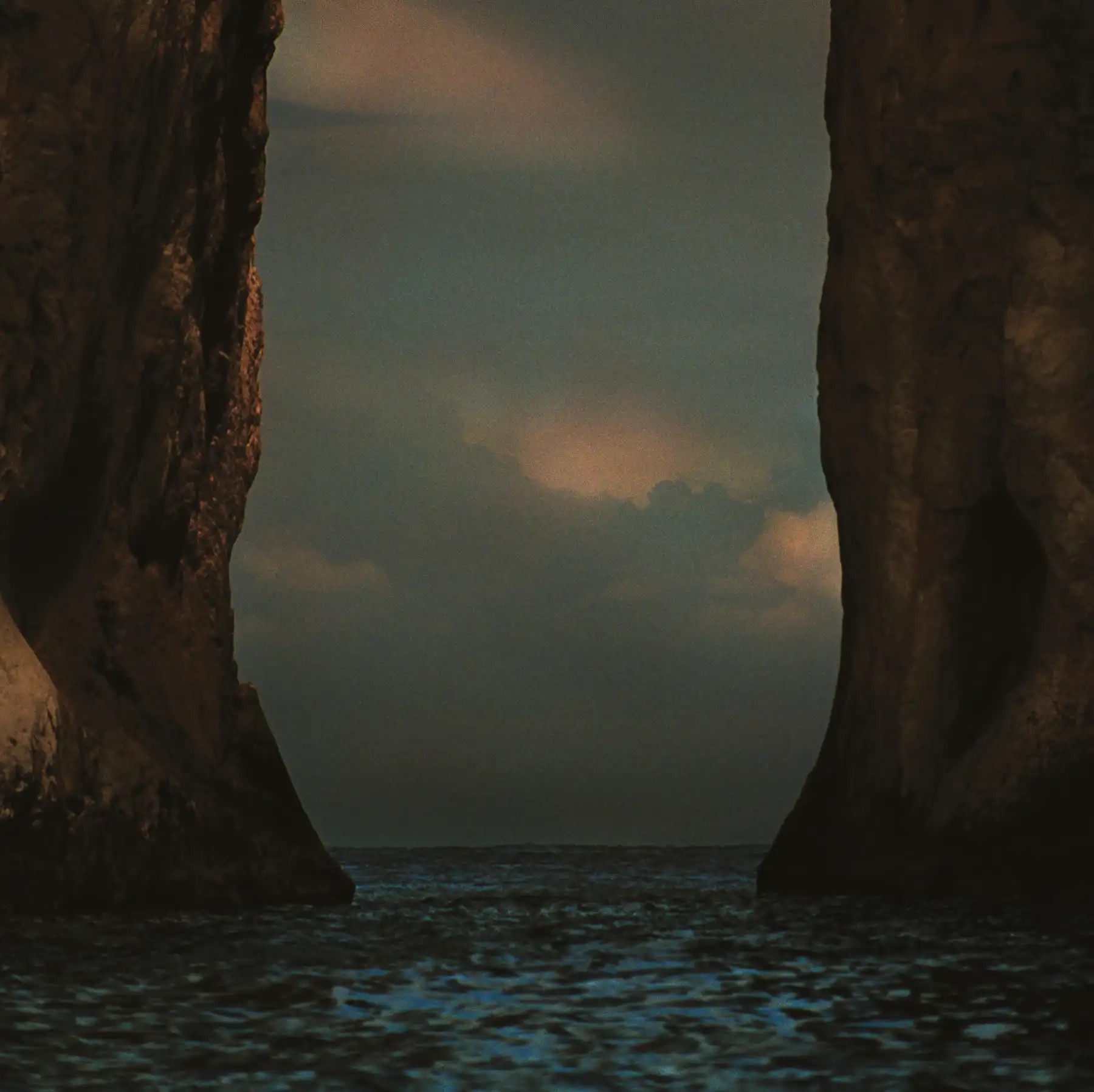 Pochette de l'album I Wrote You A Letter de M83 : un paysage marin sombre entre deux hautes falaises