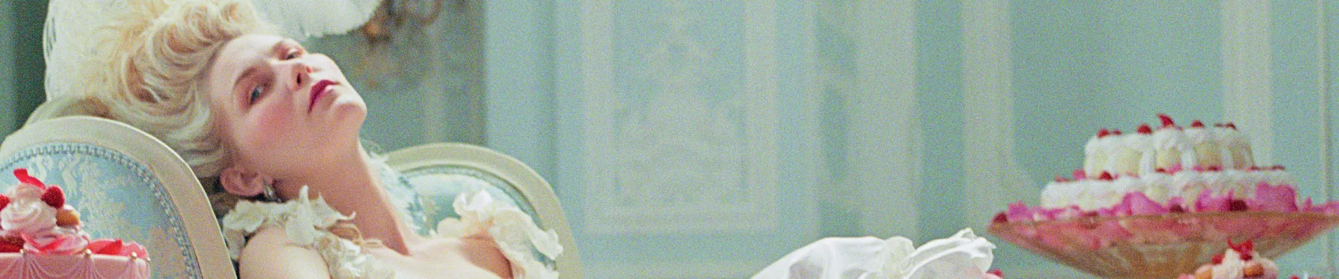 Kirsten Dunst en Marie-Antoinette, allongée près de pyramides de macarons, dans le film de Sofia Coppola