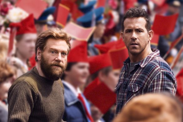 Ryan Reynolds et Kenneth Branagh dans le film Mayday, au milieu d'une foule soviétique brandissant des drapeaux rouges