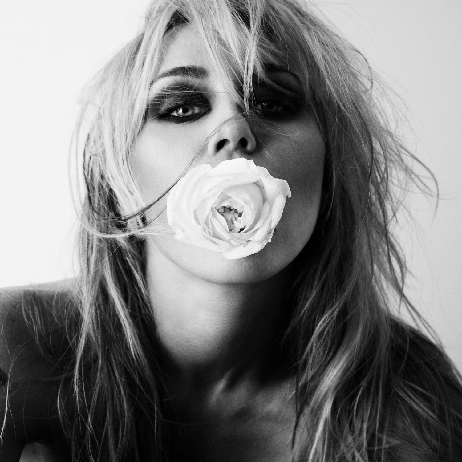 Pochette noir et blanc de l'album Bass Persuades de Miley, tenant une rose blanche entre les lèvres
