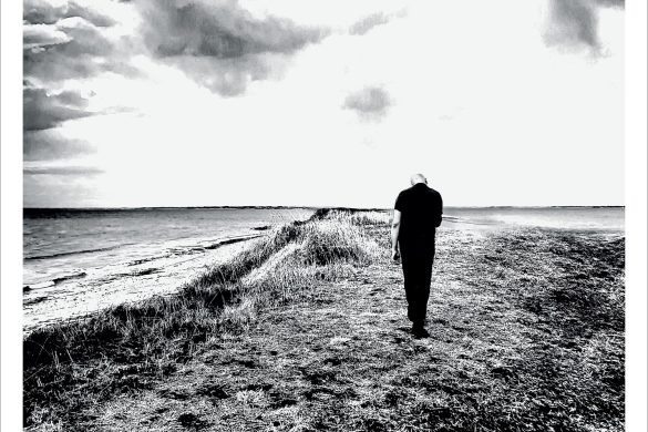 Pochette de l'album Spirales de Dominique A : une silhouette marchant sur une dune au bord de la mer, en noir et blanc
