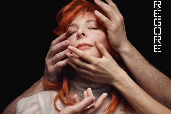 Pochette de l'album Égrégore de Mylène Farmer, visage aux yeux clos entouré de mains, chevelure rousse